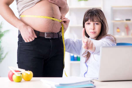 Doctor dietician giving advices to fat overweight patient