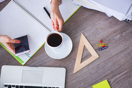 Top view of working desk with handsの写真素材