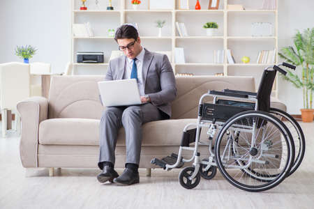Dsabled businessman on wheelchair working homeの写真素材