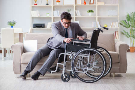 Dsabled businessman on wheelchair working homeの写真素材
