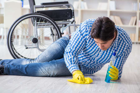 Disabled man on wheelchair cleaning homeの写真素材