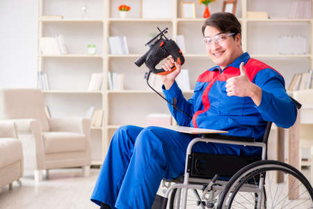 Disabled man working with handsaw at homeの写真素材