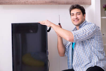 Man repairing broken tv at homeの写真素材