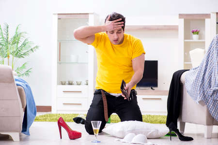 Man with mess at home after house partyの写真素材