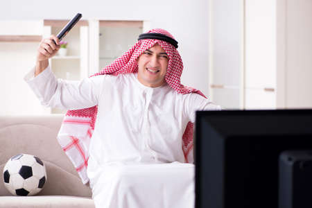 Arab man watching tv at homeの写真素材