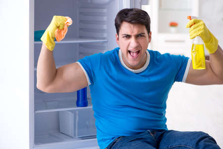 Man cleaning fridge in hygiene conceptの写真素材