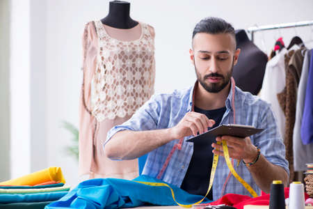 Male tailor working in the workshop on new designsの写真素材