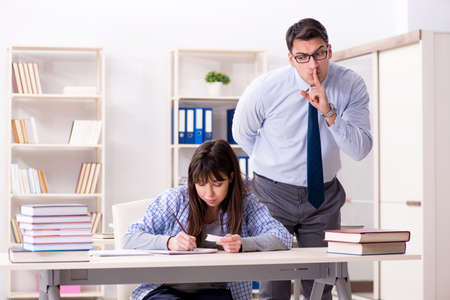 Male lecturer giving lecture to female studentの写真素材
