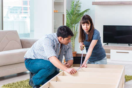 Young family assembling furniture at new houseの写真素材