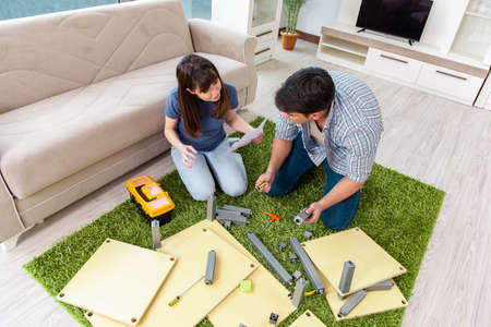 Young family assembling furniture at new houseの写真素材