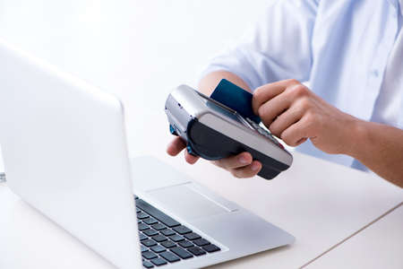 Man processing credit card transaction with POS terminal