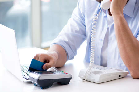 Man processing credit card transaction with POS terminal