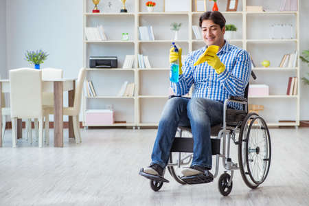 Disabled man on wheelchair cleaning homeの写真素材