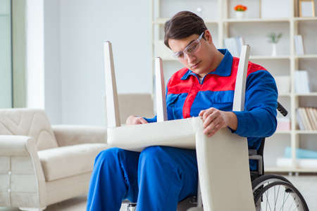 Disabled man repairing chair in workshopの写真素材