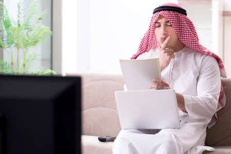 Arab man watching tv at homeの写真素材