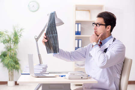 Young handsome doctor working in hospital roomの写真素材