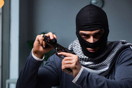 Terrorist burglar with gun asking for money ransomの写真素材