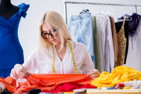 Woman tailor working on new dress designs