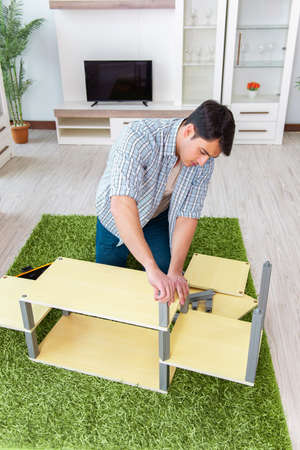 Man assembling furniture at homeの写真素材