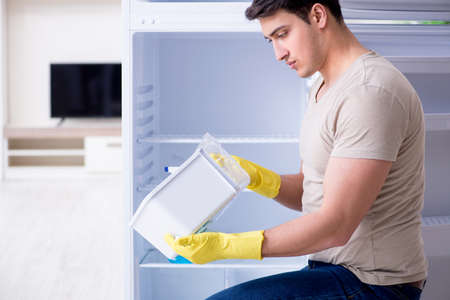Man cleaning fridge in hygiene conceptの写真素材