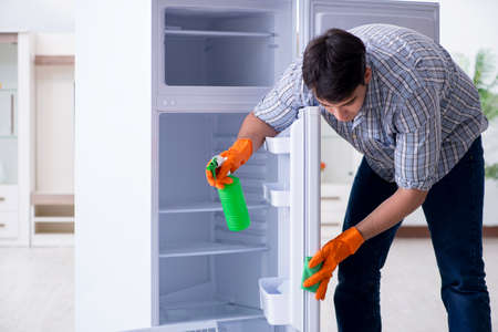 Man cleaning fridge in hygiene conceptの写真素材