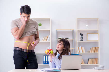 Doctor dietician giving advices to fat overweight patient