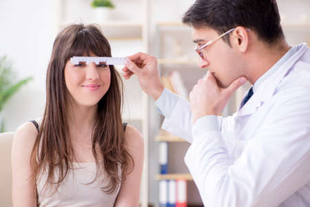 Ophthalmologist is checking up patient in eye doctor hospitalの写真素材