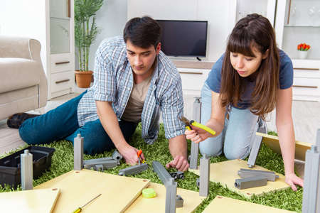Young family assembling furniture at new houseの写真素材