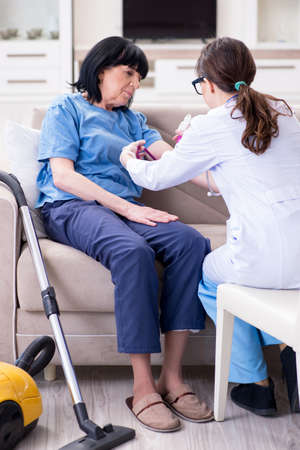 Doctor making injection to senior old womanの写真素材
