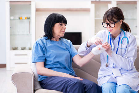 Doctor examining old mature woman after incidentの写真素材
