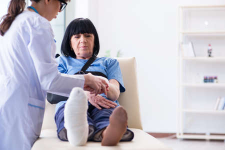 Doctor examining old mature woman after incidentの写真素材