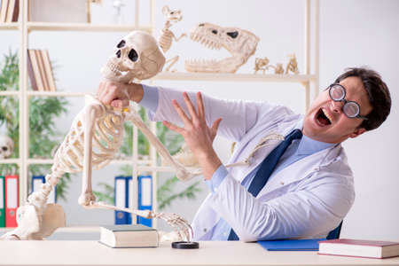 Crazy professor studying human skeletonの写真素材