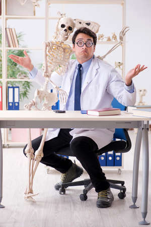 Crazy professor studying human skeletonの写真素材