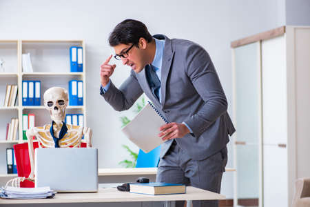 Angry boss yelling at his skeleton employeeの写真素材