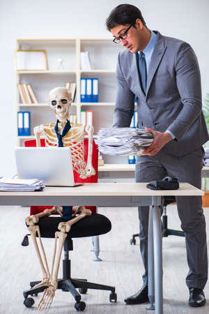 Angry boss yelling at his skeleton employeeの写真素材