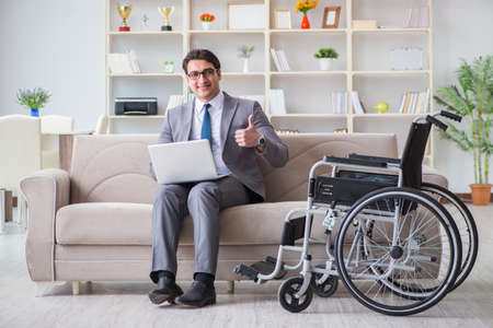 Dsabled businessman on wheelchair working homeの写真素材