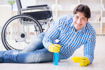 Disabled man on wheelchair cleaning homeの写真素材