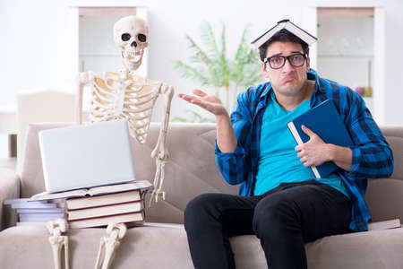 Student studying with skeleton preparing for examsの写真素材
