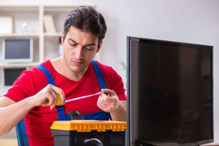 Professional repair engineer repairing broken tvの写真素材