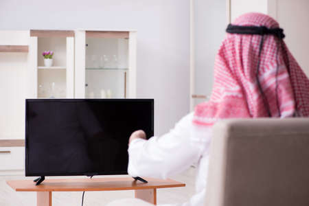 Arab man watching tv at homeの写真素材