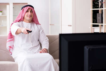 Arab man watching tv at homeの写真素材