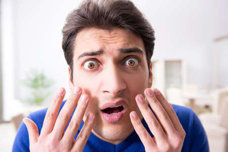 Man panicking because of pimples on the skinの写真素材