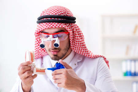Arab dentist working on new teeth implantの写真素材