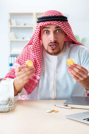 Arab man with bitcoin in cryptocurrency mining conceptの写真素材