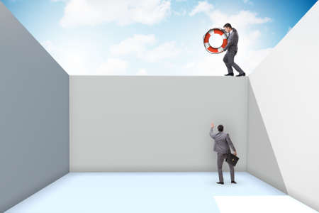 Businessman saving colleague with lifebuoyの写真素材