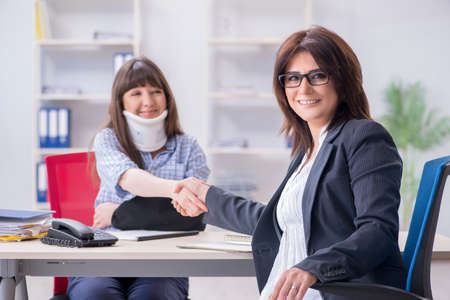 Injured employee visiting lawyer for advice on insuranceの写真素材