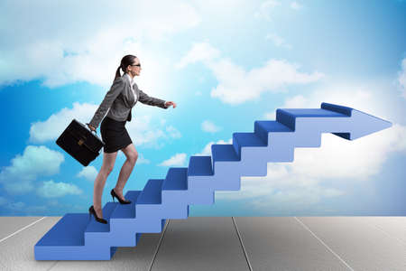 Businesswoman climbing career ladder in business conceptの写真素材