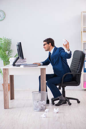 Young handsome businessman employee working in office in paperwoの写真素材