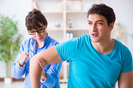 Doctor checking nerve reflexes with hammer