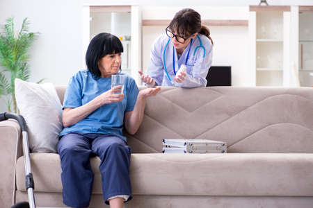 Young doctor visiting old mature woman for check-upの写真素材